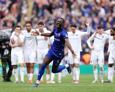 Mani Dieseruvwe of Rochdale celebrating with downcast Boreham Wood players in the background